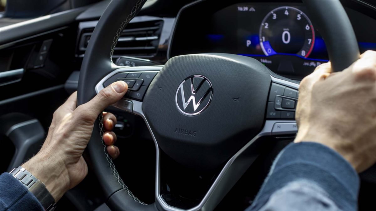 Conductor con las manos sobre un volante Volkswagen retapizado en cuero negro, con costura a la vista